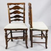 A harlequin set of eight oak and beech ladderback cottage dining chairs, with rush seats