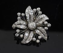 A white gold and diamond cluster set flower head brooch, with central stone weighing approximately