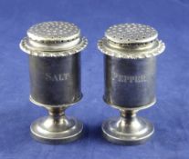 A pair of Indian? silver pedestal "salt" and "pepper" pots, of cylindrical form, each stamped with