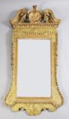A George I giltwood wall mirror, of architectural form with scallop shell and swans neck pediment,