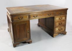 An Edwardian walnut pedestal partner`s desk, by Maple & Co, with tooled brown leather inset
