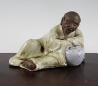 A Chinese Shiwan pottery recumbent figure of an old man, 7.3in. (18.5cm)