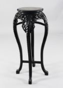 A 19th century Chinese hardwood vase stand, with red marble inset top, carved with flowers and
