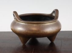 A Chinese bronze ding-shaped censer, of compressed globular form with a pair of looped handles, on