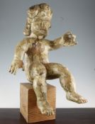 A 19th century Spanish painted pine figure of a seated putto, on a square pine base, 22in.