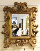 An 18th century Florentine carved giltwood wall mirror, the frame decorated with scrolling