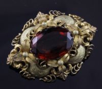 A Victorian textured and engraved gold and citrine set brooch, of oval form with oval cut stone