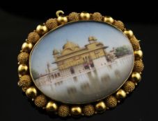 An Indian high carat gold brooch with inset painted miniature of a temple, with beaded border, 2.