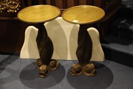 A decorative pair of carved giltwood lamp tables, with circular dish tops on entwined dolphin bases,