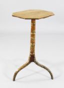 A 19th century satinwood tripod wine table, with elongated hexagonal top, the base decorated with