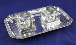An Edwardian silver inkstand, of shaped rectangular form with gadrooned border and two mounted glass