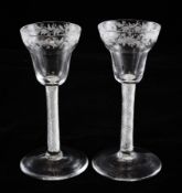 A pair of airtwist wine glasses, c.1750, the pan topped bowls wheel engraved with flowers and