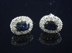 A pair of white gold, sapphire and diamond cluster ear studs, of oval form.