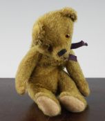 A 20th century teddy bear purse, with gold mohair and glass eyes, 9in.