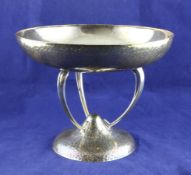 A stylish George V Arts & Crafts planished silver fruit bowl, on curved tripod supports and
