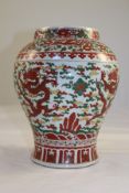 A Chinese Transitional style wucai baluster vase, painted with dragons amid clouds, 10.25in. (26cm)