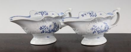 A pair of Worcester sauceboats, c.1755, with `C` scroll moulding, each painted with the zig-zag