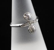 A 1920`s 18ct white gold two stone diamond crossover ring, with diamond set shank, the two collet