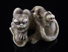 A Japanese ivory okimono netsuke of a wild cat and two cubs, 19th century, with horn inset eyes,