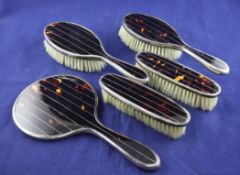 A George V silver and tortoiseshell mounted five piece brush set, comprising mirror and four
