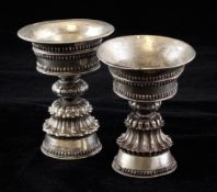 Two Tibetan silver yak butter cups, 18th / 19th century, with flared bowls and gadrooned conical