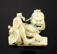 A Japanese ivory netsuke of Shoki, Meiji period, crouching with a box to catch an oni who is