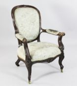 A Victorian carved oak armchair, with padded back, arms and seats, on floral carved cabriole legs