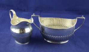 A Victorian demi fluted silver oval sugar bowl and cream jug, F.B. Thomas & Co, London, 1882 &