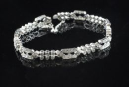 A platinum and diamond set bracelet, with open work and twin row links.