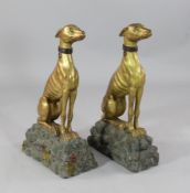 A pair of 19th century giltwood greyhounds, seated upon painted rocky plinths, H.2ft 5in. D.1ft