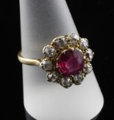 An early 20th century gold, ruby and diamond cluster ring, of flower head design, with central