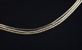 An 18ct two colour gold triple strand bracelet, 22.7 grams, 7.5in.