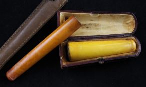 An early 20th century French 18ct gold mounted amber cigar holder and a gold mounted amber cigarette