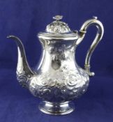 A Victorian silver coffee pot, of pear form, embossed with foliate scrolls and bird above a vacant