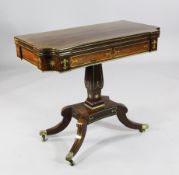A Regency brass inset rosewood card table, with folding top, saltire platform and downswept legs and