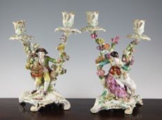 A pair of large Chelsea figural twin branch candelabra, c.1765, the first a seated gentleman holding