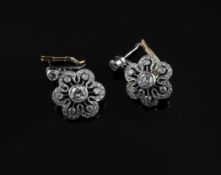 A pair of white and yellow gold, diamond set flower head drop earrings, 0.75in.