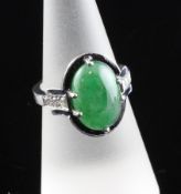 A white gold, jadeite, diamond and deep blue enamel dress ring, the central oval jadeite cabochon