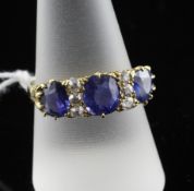 An 18ct gold sapphire and diamond half hoop dress ring, set with three graduated oval cut sapphire