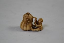 A Japanese ivory netsuke of a man cutting a giant gourd, early 20th century, signed Tamamitsu or