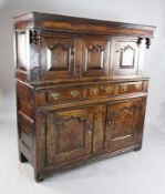 A late 17th century oak court cupboard, the canopied top above arched full panels with two cupboards
