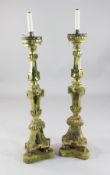 A pair of mid 18th century Italian giltwood altar sticks, on green velvet plinths, fitted for