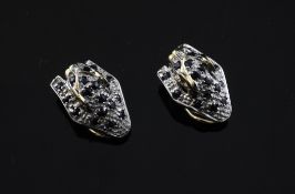 A pair of gold, diamond and sapphire set ear clips, modelled as recumbent leopards, 0.75in.