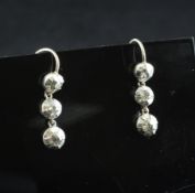 A pair of early 19th century style white gold and three stone diamond drop earrings, 0.75in.