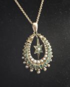 A late Victorian gold, emerald and split pearl set pendant, of horseshoe shape with central