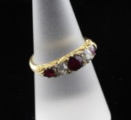 An early 20th century 18ct gold and graduated five stone ruby and diamond set half hoop ring, size