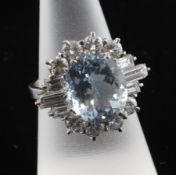A 1970`s 18ct white gold. aquamarine and diamond cluster dress ring, the oval cut aquamarine with