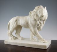 A large early 19th century Italian carved marble model of a pacing lion, on a rectangular base,