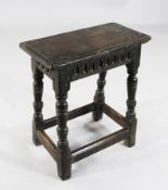 A James II oak joynt stool, the top with moulded edge over a fluted frieze, on ring turned supports,