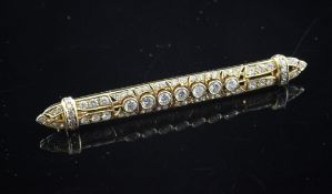 A gold and diamond set bar brooch, with pierced setting, 2.5in.